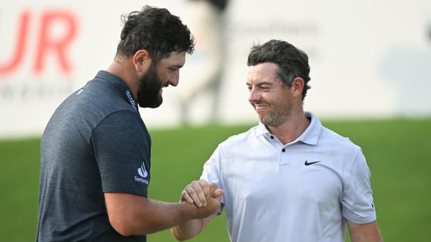 Jon Rahm shakes hands with Rory McIlroy on the 18th green during the first round of the TOUR Championship golf tournament at East Lake Golf Club.